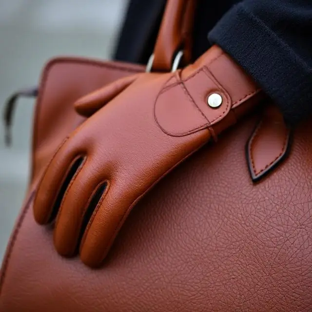 Detalle de un bolso de cuero y un guante